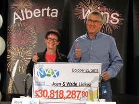 New millionaires Joan and Wade Lidkea holds their cheque for $30,818,287.80 at the Alberta Gaming & Liquor Commission office in St Albert, Alberta on Thursday, October 23, 2014.  Perry Mah/Edmonton Sun