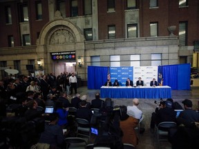 New York Mayor Bill de Blasio (table, C) and New York Governor Andrew Cuomo (table, 2nd R) attend a news conference in Bellevue Hospital in New York October 23, 2014. REUTERS/Eduardo Munoz