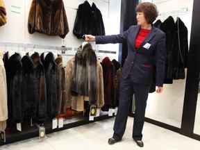 A sales woman displays a mink coat to customers at a shopping mall in Shanghai, April 4, 2013. (REUTERS)