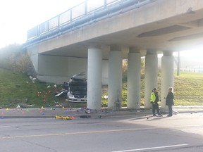 A badly mangled vehicle sits on the grass under a train overpass along Merivale Rd. after a high-speed overnight crash Friday, October 24, 2014. Two people were cut out of the wreck. (DANIELLE BELL Ottawa Sun)