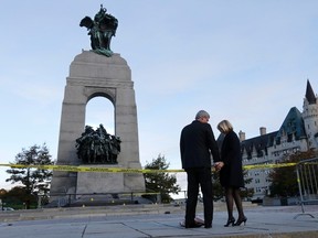 Prime Minister Stephen Harper and his wife Laureen Harper pay their respects to Cpl. Nathan Cirillo at the Canada War Memorial in Ottawa October 23, 2014.  Cirillo was killed during a shooting incident at the Memorial October 22. The gunman then ran into Parliament, shooting, before he was killed by police.        REUTERS/Chris Wattie