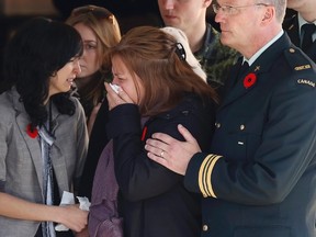 Kathy Cirillo, centre, the mother of Cpl. Nathan Cirillo, reacts as his casket is placed in a hearse at a funeral home in Ottawa on Friday, Oct. 24, 2014. (REUTERS)