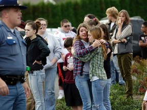 Two girls hug at Shoultes Gospel Hall church where families are reuniting after an active shooter situation at Marysville-Pilchuck High School in Marysville, Washington October 24, 2014. A student opened fire at his Washington state high school, Marysville-Pilchuck High School, on Friday, killing one person, wounding at least four others and spreading panic among students who scrambled across fields and parking lots to safety, police and hospital officials said. The shooter acted alone and is now dead following the incident, police said.  REUTERS/Jason Redmond