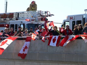 Members of the public along with military members stand along the Hwy. 15 overpass in Kingston on Friday October 24 2014 to pay their respects to Cpl. Nathan Cirillo who's body was being transferred from Ottawa to Hamilton with a police escort. (IAN MACALPINE-KINGSTON WHIG-STANDARD/QMI AGENCY