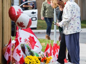 People pay their respects to a memorial of flowers, cards and greetings at the home of slain soldier  Cpl. Nathan Cirillo in Hamilton, Ont. on Friday October 24, 2014. Ernest Doroszuk/Toronto Sun/QMI Agency