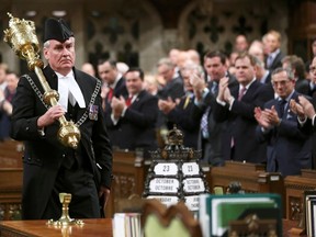 Sergeant-at-Arms Kevin Vickers is applauded in the House of Commons in Ottawa October 23, 2014. Vickers was credited with shooting the suspect during a shooting incident October 22, in which a gunman killed a soldier and ran through Parliament shooting before being shot dead himself.      REUTERS/Chris Wattie