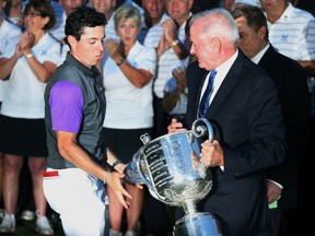 Rory McIlroy (left) catches the Wanamaker Trophy as it slips out of the hands of PGA president Ted Bishop when presented after winning the 2014 PGA Championship in Louisville, Ky. on Aug. 10, 2014. Bishop was fired Oct. 24 due to insensitive social media comments towards Ian Poulter. (Brian Spurlock-USA TODAY Sports)