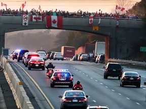 The procession carrying the body of Cpl. Nathan Cirillo, advances along the Highway of Heroes, on route to Hamilton, on Friday, Oct. 24, 2014. (Veronica Henri/QMI Agency)