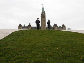 Royal Canadian Mounted Police officers stand guard on Parliament Hill in Ottawa October 23, 2014. A gunman attacked Canada's parliament on Wednesday, with gunfire erupting near a room where Prime Minister Stephen Harper was speaking, and a soldier was fatally shot at a nearby war memorial, jolting the Canadian capital.  REUTERS/Chris Wattie