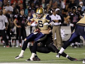 Defensive lineman Justin Capicciotti of the Ottawa Redblacks tackles quarterback Drew Willy of the Winnipeg Blue Bombers earlier this month. The Bombers are poised to deliver the biggest choke in CFL history. (Jana Chytilova/Getty Images/AFP file photo)
