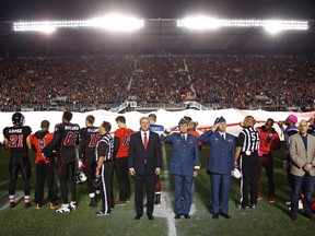Canada's Prime Minister Stephen Harper (centre-L) and Canada's Chief of the Defence Staff General Tom Lawson (centre-R) take part in a tribute to recently fallen Canadian soldiers, prior to a CFL football game between Ottawa Redblacks and Montreal Alouettes in Ottawa October 24, 2014. Corporal Nathan Cirillo and Warrant Officer Patrice Vincent both recently died during attacks in Canada.     REUTERS/Blair Gable     (CANADA - Tags: POLITICS MILITARY CRIME LAW SPORT FOOTBALL TPX IMAGES OF THE DAY)