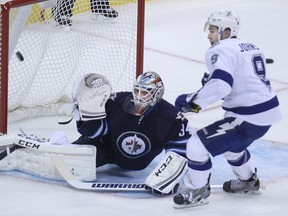 Winnipeg Jets goaltender Michael Hutchinson makes a save with Tampa Bay Lightning centre Tyler Johnson looking for a rebound during NHL action at MTS Centre in Winnipeg, Man., on Fri., Oct. 24, 2014. Kevin King/Winnipeg Sun/QMI Agency