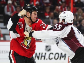 Senators forward Chris Neil (left) fights with Cody McLeod of the Avalanche during NHL action at the Canadian Tire Centre in Ottawa on Thursday, Oct. 16, 2014. (Errol McGihon/Ottawa Sun)