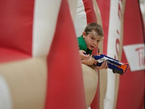 Jaydon Pye, 8, leans out of the giant, inflatable-bouncy castle he was protecting during 'Nerf Mania' at the Allan & Jean Millar centre, in Whitecourt, Alta. on Saturday, Oct. 18, 2014. 'Nerf Mania,' a three-hour long Nerf-gun fight, was part of the community fun night events organized in partnership between the town of Whitecourt and Tim Horton's. The events are different each month and run on the second Saturday of each month from September to June. 
Adam Dietrich | Whitecourt Star photo