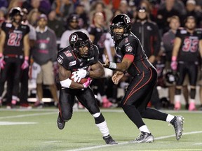 OTTAWA, ON - OCTOBER 24: Quarterback Henry Burris #1 of the Ottawa Redblacks hands the ball off to team mate running back Roy Finch #19 during a CFL game against the Montreal Alouettes at TD Place Stadium on October 24, 2014 in Ottawa, Ontario, Canada.   Jana Chytilova/Freestyle Photography/Getty Images/AFP== FOR NEWSPAPERS, INTERNET, TELCOS & TELEVISION USE ONLY ==