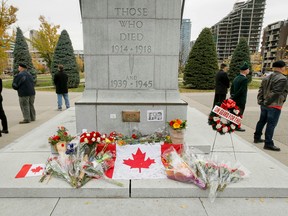 Veterans hold a vigil around the cenotaph at Central Memorial Park in Calgary, Alta., on October 25, 2014. The vigil was held for Warrant Officer Patrice Vincent and Cpl. Nathan Cirillo, who were both killed while unarmed in targeted attacks within a single week. (Lyle Aspinall/QMI Agency)