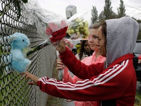 Student Tyanna Davis, right, and others place flowers outside Marysville-Pilchuck High School the day after a shooting at the school in Marysville, Wash., on October 25, 2014. (REUTERS/Jason Redmond)