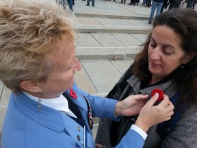 Helen Walsh from the Canadian Association of Veterans in United Nations Peacekeeping pins a poppy on Francine Proulx of Montreal after being asked for one at the National War Memorial Saturday, Oct. 25, 2014. Proulx was one of thousands paying respect to Cpl. Nathan Cirillo, gunned down in an Oct. 22 terror attack while guarding the Tomb of the Unknown Soldier.
KELLY ROCHE/OTTAWA SUN/QMI AGENCY