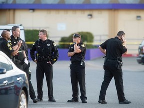 Sacramento County Sheriff Lieutenant Palmer covers his face while gathered with fellow officers near a Motel 6 parking lot where Sheriff's Deputy Danny Oliver was killed in Sacramento, California October 24, 2014. (REUTERS/Noah Berger)