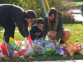 Cpl. Nathan Cirillo's son, Marcus, explored some of the toys Saturday that were left for home at memorial set up outside the family's Hamilton home. (Chris Doucette/Toronto Sun)