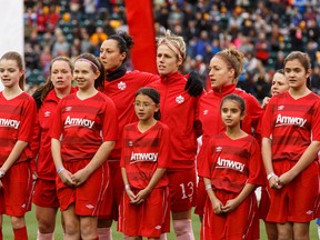 Team Canada and young soccer players sing O Canada prior to Saturday's friendly with Japan at Commonwealth Stadium (Ian Kucerak, Edmonton Sun).