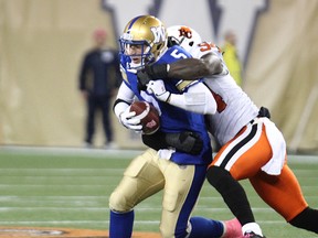 Winnipeg Blue Bomber QB Drew Willy is sacked by B.C. Lions DE Khreem Smith during CFL action at Investors Group Field in Winnipeg, Man., on Sat., Oct. 25, 2014.