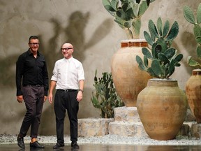 Designers Domenico Dolce (R) and Stefano Gabbana acknowledge the audience at the end of their Spring/Summer 2013 collection at Milan Fashion Week in this Sept. 23, 2012 file photo. Italy's top court cleared the designers Friday over charges of hiding hundreds of millions of euros from Italian tax authorities. REUTERS/Stefano Rellandini/Files