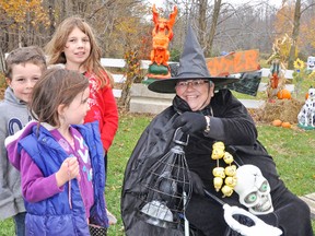 Cousins Emma (front), Carson and Alicia Paulen stop to talk to witch Mary Jane Runhart at the Mitchell Optimist Spook-tacular event held this past Saturday afternoon, Oct. 25, on the Vorstenbosch farm. KRISTINE JEAN/MITCHELL ADVOCATE