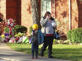 Crystal Burtt, 24, wipes tears from her eyes as she escorts her five-year-old son Diesel from the public visitation for Cpl. Nathan Cirillo on Monday, October 27, 2014 in Hamilton. (Stan Behal/Toronto Sun)