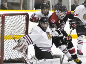 Mitchell Hawks’ goalie Clay Carter makes a save from close range as Walkerton Hawks’ Brett Coulson (19) jams the crease during Western Jr. C hockey action Sunday in Mitchell. The locals dropped a 6-2 decision to the first-place visitors. ANDY BADER/MITCHELL ADVOCATE