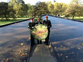 From left, Cpl. Jason Moore, Deputy High Commissioner Alan H. Kessel and Cpl. Tyler Brenedet with a traditional wreath at the Canadian Memorial in London during a special memorial service for Nathan Cirillo and Patrice Vincent Monday, Oct. 27, 2014. (Supplied)