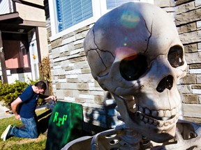 Gary Hartford works on a front yard Halloween display at his Mill Woods home in Edmonton, Alta., on Sunday, Oct. 12, 2014. Codie McLachlan/Edmonton Sun/QMI Agency