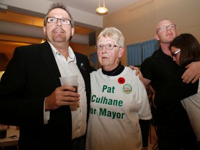 City councillor Egerton Boyce comforts Pat Culhane while she watches Taso Christopher take the lead in the mayoral race Monday evening. Culhane gathered with hundreds of supporters at the Masonic Lodge to watch the evening unfold. Christopher was elected with 3,914 votes to Culhane's 3,753. At right is Culhane's niece Carly and Culhane's son Tim. 
Emily Mountney-Lessard/The Intelligencer/QMI Agency.