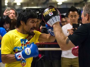 Boxer Manny Pacquiao (left) practices with trainer Freddie Roach (right) during a media workout in Hong Kong on Monday, Oct. 27, 2014. (Tyrone Siu/Reuters)