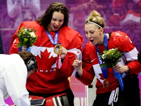 Team Canada players Shannon Szabados and Meghan Agosta-Marciano mug for a TV camera as they celebrate their hockey gold medal at the Bolshoy Ice Dome at the Sochi Winter Olympics on Feb. 20, 2014. The IOC awarded the CBC the broadcast rights to the 2018 and 2020 Olympic Games on Tuesday. (Al Charest/QMI Agency/Files)