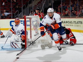 Travis Hamonic of the New York Islanders defends against the New Jersey Devils on Oct. 2, 2014.