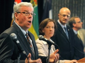 Manitoba Premier Greg Selinger (left) speaks as Alberta Premier Alison Redford (centre) looks on, May 29, 2012.