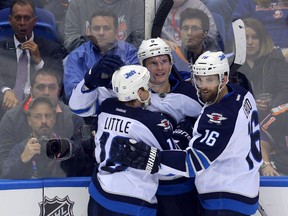 Oct 28, 2014; Uniondale, NY, USA; Winnipeg Jets defenseman Jacob Trouba (8) celebrates his goal with center Bryan Little (18) and left wing Andrew Ladd (16) during the second period against the New York Islanders at Nassau Veterans Memorial Coliseum. The Jets defeated the Islanders 4-3. Mandatory Credit: Brad Penner-USA TODAY Sports