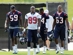 HOUSTON - MAY 21: Linebacker Whitney Mercilus #59, Jerrell Jackson #89 and D.J. Bryant #63 of the Houston Texans arrive for the first day of OTA's at the Methodist Training Center at Reliant Park on May 21, 2012 in Houston, Texas.  Bob Levey/Getty Images/AFP