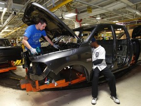Chrysler Group LLC assembly workers put together a 2014 Ram 1500 pickup truck on the assembly line at the Warren Truck Plant during a tour of the plant's redesigned work stations in Warren, Michigan, September 25, 2014. (REUTERS/Rebecca Cook)