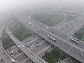 Vehicles drive on the Sihui overpass amid heavy haze and smog in Beijing, in this October 11, 2014 file picture. China's capital is expected to face more heavy smog from October 29, 2014 as it battles to try to guarantee air quality ahead of an Asia-Pacific Economic Cooperation (APEC) summit starting on Saturday, forecasters said. REUTERS/Jason Lee/Files