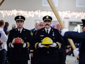 Aaron Floyd (left), deputy fire chief, and Troy DuFort (right), deputy fire chief, march-in the ceremonial helmets at the 2014 annual firefighter awards night on Saturday, Oct. 25.
