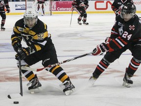 Kingston Frontenacs forward Corey Pawley keeps the puck from the Niagara Ice Dogs’ Hayden McCool during Ontario Hockey League action at the Rogers K-Rock Centre on Oct. 12. (JULIA MCKAY/The Whig-Standard)