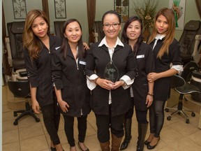 Phuong Pham, centre, owner of Fantastic Nails and Spa, holds the Integrity Award her business won Wednesday from the Better Business Bureau of Western Ontario. With Pham are employees Tin Aguilar, left, Suzi Pham, Trang Nguyen, and Ann Aguilar. (DEREK RUTTAN/The London Free Press)