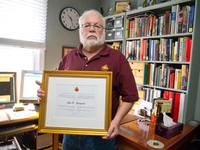 John Sargeant is reflected in an award for his work with veterans, given to him by Minister of Veterans Affairs Julian Fantino, in his home in London Sunday. Sargeant is one of 20 Ontarians given recognition for their work promoting veterans? causes. (CRAIG GLOVER/The London Free Press)