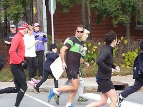 Low-impact running coach Mike Stashin, wrapping up his 14th marathon in as many days, was greeted by kids from St. Anthony School on Booth St. on Wed. Oct. 29, 2014. KELLY ROCHE/OTTAWA SUN/QMI AGENCY