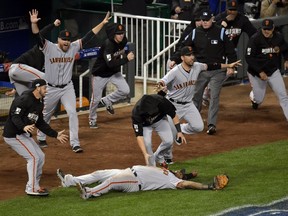Giants third baseman Pablo Sandoval (bottom) celebrates with teammates after catching a pop out for the final out of Game 7 of the World Series against the Royals in Kansas City, Mo., on Wednesday, Oct. 29, 2014. (Denny Medley/USA TODAY Sports)