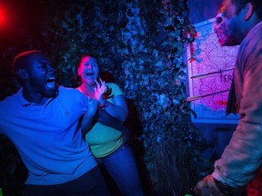 A couple reacts to one of the exhibits in the "AMC's The Walking Dead" haunted house at Universal Orlando Resort in Orlando, Florida, in this undated handout photo provided by Universal Orlando. REUTERS/Universal Orlando/Handout via Reuters