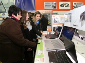 In this file photo, Alexis Poirier, right, of Best Buy, shows Lise Longchamp and her daughter, Anik, a selection of laptop computers at the store on Dec. 27, 2013. Boxing Day sales were brisk at Best Buy. JOHN LAPPA/THE SUDBURY STAR