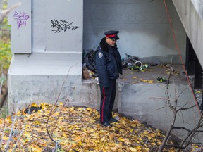 Police work at the scene Thursday where a burned body was reportedly found the night before. (ERNEST DOROSZUK/Toronto Sun)